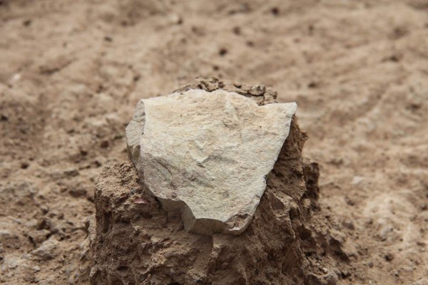 This undated photo made available in May 2015 by the Mission Prehistorique au Kenya - West Turkana Archaeological Project shows the excavation of a stone tool found in the West Turkana area of Kenya. This and other artifacts, dated at 3.3 million years old, are much older than the earliest known trace of our own branch of the evolutionary family tree. So it’s a new challenge to the traditional idea that only members of our branch made stone tools. The discovery was reported in the journal Nature on Wednesday, May 20, 2015. (MPK-WTAP via AP)