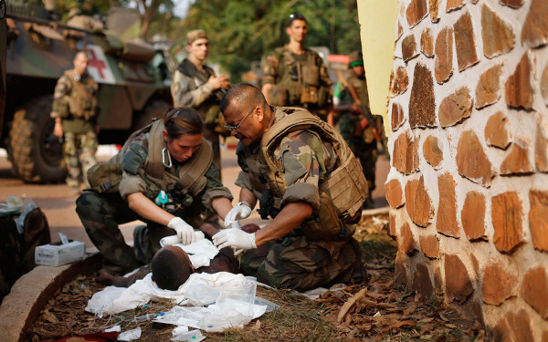 French medics treat a man they found in a cell with a slit throat after Seleka Muslim militias evacuated the Camp de Roux downtown Bangui, Central African Republic, Monday, Jan. 27, 2014, to relocate and join other Selekas at the PK11 camp.