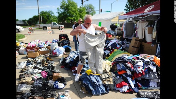 Tornado victim Todd (who only gave one name) looks through a pile of clothing at a road side relief camp on May 22, 2013 in Moore, Oklahoma. As rescue efforts in Oklahoma wound down, residents turned to the daunting task of rebuilding a US heartland community shattered by a vast tornado that killed at least 24 people. The epic twister, two miles (three kilometers) across, flattened block after block of homes as it struck mid-afternoon on May 20, hurling cars through the air, downing power lines and setting off localized fires in a 45-minute rampage.AFP PHOTO/Jewel Samad        (Photo credit should read JEWEL SAMAD/AFP/Getty Images)