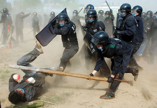 South Korean riot police use force to break up a protest in Pyeongtaek, South Korea, about 65 kilometers south of Seoul, and near the U.S. military facility Camp Humphreys, on Thursday, May 4, 2006. Police using shields and wielding batons clashed with villagers and students who were protesting the expansion of a U.S. military base that will house the military's new headquarters in South Korea. Photographer: Seokyong Lee / Bloomberg News