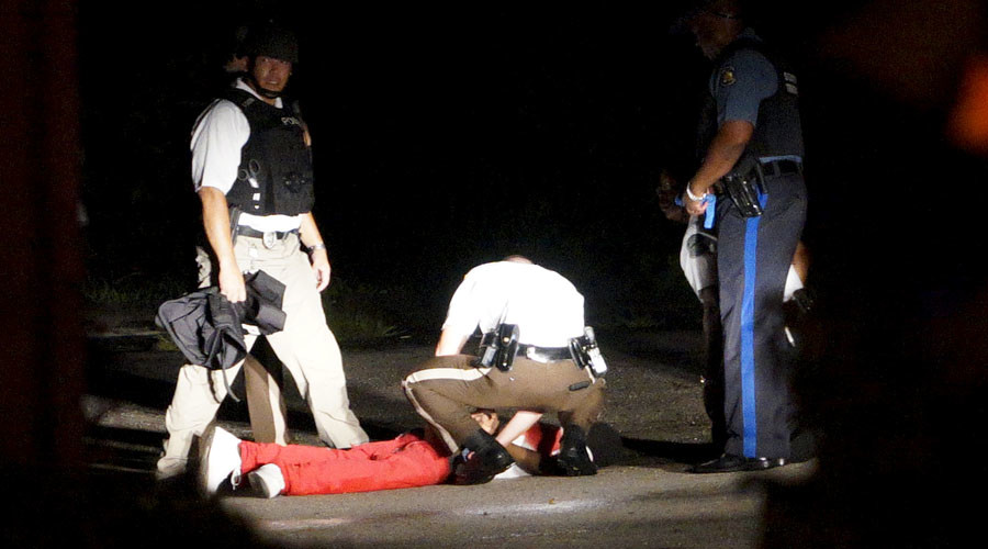 ATTENTION EDITORS - VISUAL COVERAGE OF SCENES OF INJURY OR DEATHA black man lies badly wounded with blood on his shirt after a police officer involved shooting in Ferguson, Missouri August 9, 2015. Two people were struck by gunfire in the midst of a late-night confrontation on Sunday between riot police and protesters, police said, after a day of peaceful events commemorating the fatal shooting of an unarmed black teenager by a white officer one year ago.   REUTERS/Rick Wilking  - RTX1NPRL