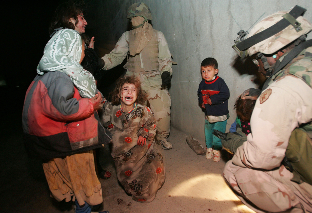 TAL AFAR, IRAQ - JANUARY 18:  Iraqi children cry after their parents were killed when U.S. Soldiers with the 1st Battalion, 5th Infantry Stryker Brigade Combat Team of the 25th Infantry Division out of Ft. Lewis, Washington, fired on their car when it failed to stop and came toward soldiers despite warning shots during a dusk patrol January 18, 2005 in Tal Afar, Iraq. The car held an Iraqi family of which the mother and father were killed. According to the U.S. Army, six children in the in the car survived, one with a non-life threatening flesh wound. U.S. military said they are is investigating the incident. (Photo by Chris Hondros/Getty Images)