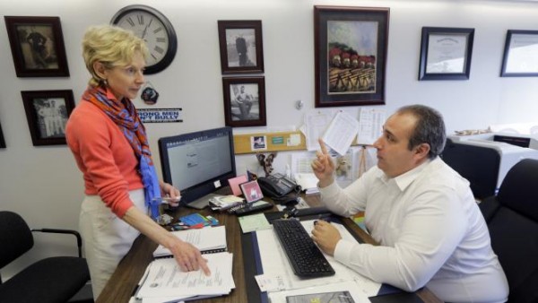 Police Chief Leonard Campanello confers with Joan Whitney, director of the Healthy Gloucester Collaborative, at his office in Gloucester, Mass., Monday, June 1, 2015. Gloucester Police are launching a new program this week, promising heroin addicts they won't be arrested if they bring their drugs to the police station. Chief Campanello says instead, addicts will be given help. (AP Photo/Elise Amendola)