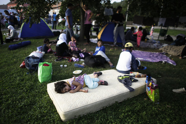 A girl sleeps on a mattress alongside other refugees waiting to cross the border to Slovenia at the Croatian village of Harmica, Friday, Sept. 18, 2015. (AP Photo/Markus Schreiber)