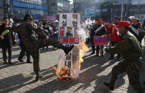 A member of a South Korean conservative group kicks a burning banner with a portrait of North Korean leader Kim Jong Un and North Korean flags during a rally denouncing the North, in Paju, South Korea.