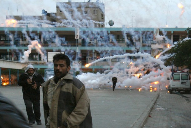 Palestinian civilians and medics run to safety during an Israeli strike over a UN school in Beit Lahia, northern Gaza Strip early on January 17, 2009. A woman and a child were killed early today in the Israeli strike on the UN-run school in northern Gaza where civilians were sheltering from the fighting, medics and witnesses said. Fierce clashes were underway around the school as Israeli tanks exchanged fire with Palestinian militants, they said. AFP PHOTO / MOHAMMED ABED ALTERNATIVE CROP (Photo credit should read MOHAMMED ABED/AFP/Getty Images)