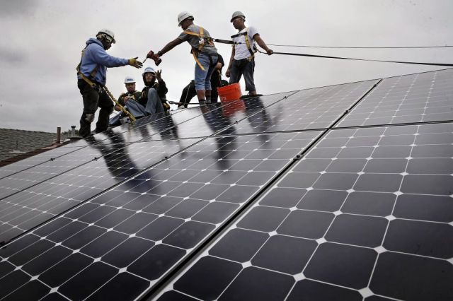 Image Source: SF Gate - Frank Ross with Grid Alternatives, (left) works with youth from The Rising Sun Energy Center job training program as they install solar panels on the roof of a home in Richmond, California.