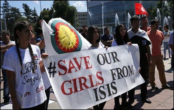 Women hold a banner during a demonstration marking the first anniversary of Islamic State's surge on Yazidis of the town of Sinjar, in front of the United Nations European headquarters in Geneva