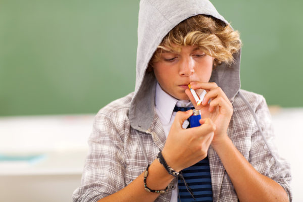 teen boy lighting cigarette