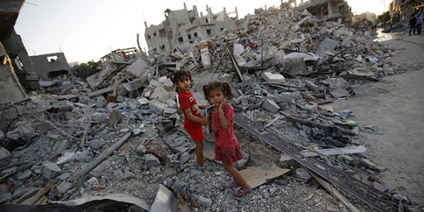 Sisters walk among the rubble of destroyed home in Gaza Strip