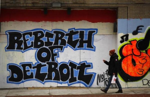 A man walks past graffiti in Detroit